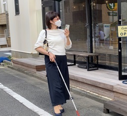 視覚障害者の方がアイコサポートを利用して街に出ている写真